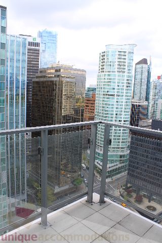 Spacious 1-bedroom condo with a stunning city view from the balcony, featuring modern furnishings and a sleek design.