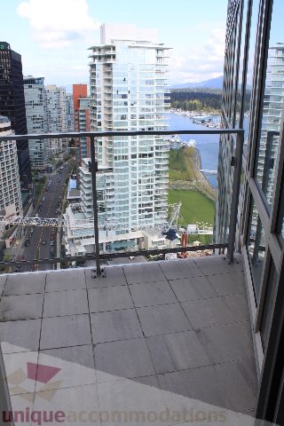Spacious balcony with stunning city and waterfront views, perfect for relaxing and enjoying the scenery.