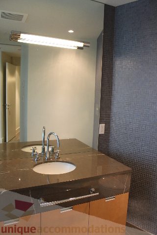 Modern bathroom with sleek countertop and blue mosaic tile walls. - 2205 - 1077 West Cordova, Vancouver Downtown