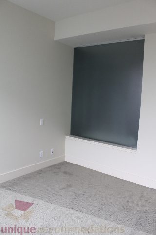 Spacious living room with dark accent wall and carpeted floor. - 2205 - 1077 West Cordova, Vancouver Downtown