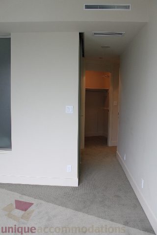 Spacious hallway leading to a cozy bedroom with carpeted floors and a neutral color palette. - 2205 - 1077 West Cordova, Vancouver Downtown