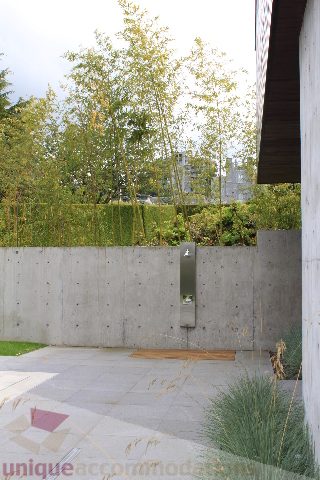 Outdoor patio with concrete walls and bamboo plants. - 6012 Newton Wynd, Vancouver West Side