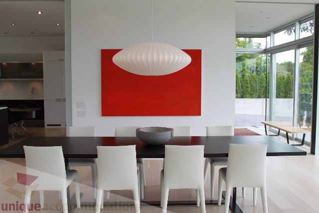 Modern dining area with red accent wall and large windows. - 6012 Newton Wynd, Vancouver West Side
