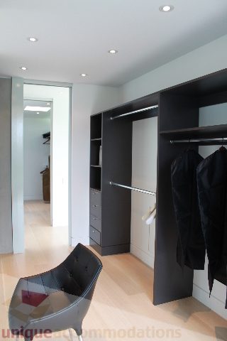 Spacious walk-in closet with modern shelves and hanging space, light wood flooring. - 6012 Newton Wynd, Vancouver West Side