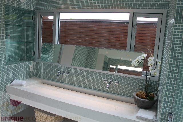Bathroom with mosaic tiles, modern sink, and orchid decor. - 6012 Newton Wynd, Vancouver West Side