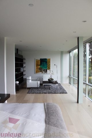 Furnished living room with hardwood floors, large windows, and a modern art piece. - 6012 Newton Wynd, Vancouver West Side