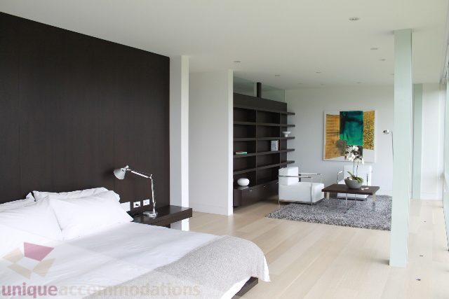 Spacious bedroom with modern furnishings and large windows. - 6012 Newton Wynd, Vancouver West Side