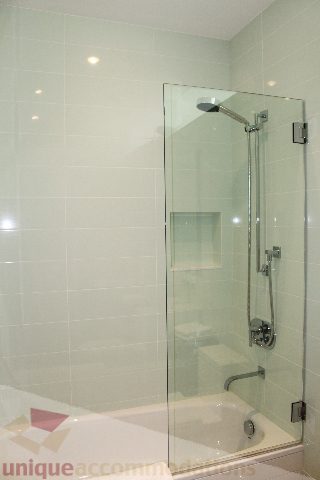 Modern bathroom with glass shower and white tile walls. - 6012 Newton Wynd, Vancouver West Side