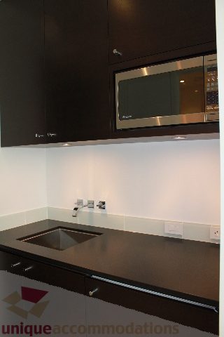Bright kitchen with modern black countertops and sleek stainless steel appliances. - 6012 Newton Wynd, Vancouver West Side