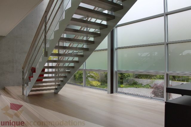 Staircase with glass railings leading to upper level, modern design. - 6012 Newton Wynd, Vancouver West Side
