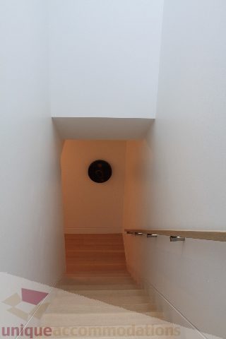 Staircase leading to upper floor with wooden steps and metal handrails. - 6012 Newton Wynd, Vancouver West Side