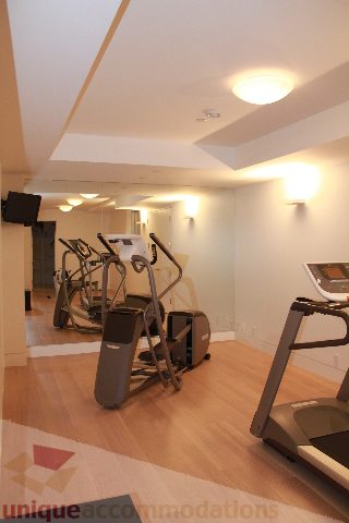 Fitness room with cardio equipment and hardwood floors. - 6012 Newton Wynd, Vancouver West Side