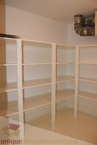 Bright and spacious living room with white shelving units and a clean, minimalist design. - 6012 Newton Wynd, Vancouver West Side