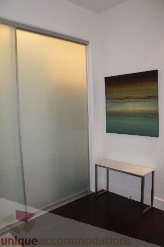 Bright bedroom with sliding glass door and modern artwork on the wall. - 6002 - 1128 West Georgia, Vancouver Downtown