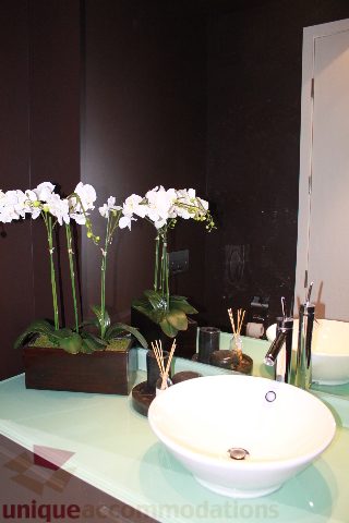 Bathroom with modern sink, sleek countertop, and orchid decor. - 6002 - 1128 West Georgia, Vancouver Downtown
