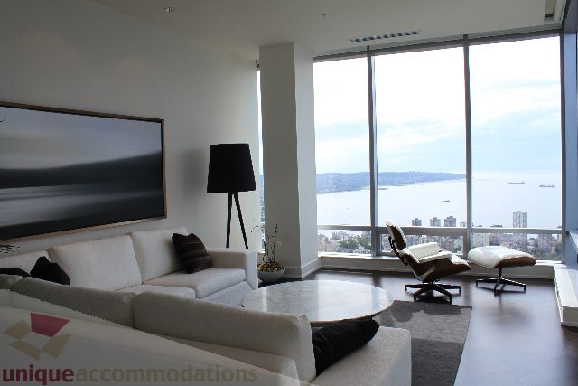 Furnished living room with large windows offering a stunning city view and modern decor. - 6002 - 1128 West Georgia, Vancouver Downtown