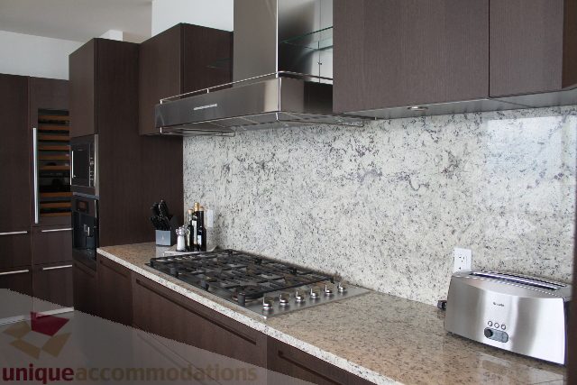 Bright kitchen with granite countertops and modern appliances, showcasing a sleek design. - 6002 - 1128 West Georgia, Vancouver Downtown
