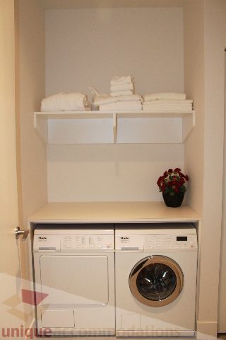 Laundry room with stacked towels and modern appliances. - 6002 - 1128 West Georgia, Vancouver Downtown