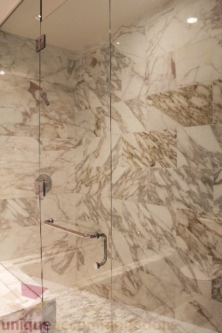 Furnished bathroom with marble walls and glass shower door. - 6002 - 1128 West Georgia, Vancouver Downtown