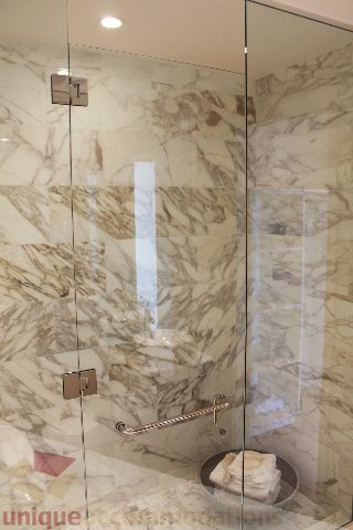 Furnished bathroom with marble walls and glass shower door. - 6002 - 1128 West Georgia, Vancouver Downtown