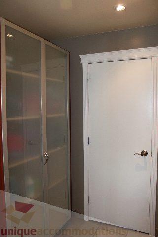 Bright bedroom with glass-front closet and white door. - 2730 Ailsa Crescent, North Vancouver