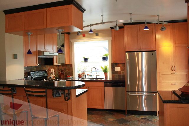 Bright kitchen with stainless steel appliances, granite countertops, and wooden cabinets. - 2730 Ailsa Crescent, North Vancouver