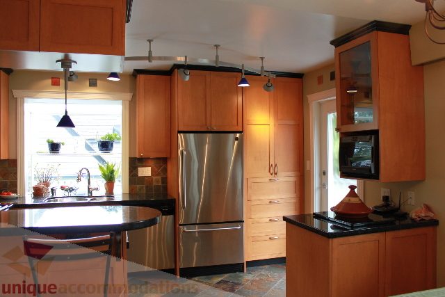 Bright kitchen with wooden cabinets, stainless steel appliances, and a window view. - 2730 Ailsa Crescent, North Vancouver