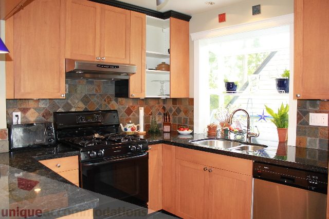 Bright kitchen with granite countertops, wooden cabinets, and a window view. - 2730 Ailsa Crescent, North Vancouver