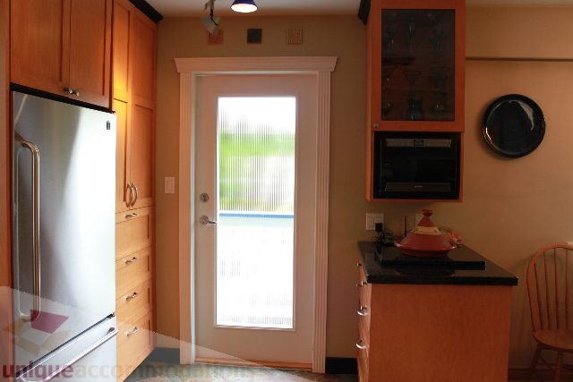 Bright kitchen with wooden cabinets, stainless steel appliances, and a view of the outdoors. - 2730 Ailsa Crescent, North Vancouver