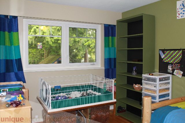 Bright living room with green shelving and colorful curtains, showcasing a cozy and vibrant space. - 2730 Ailsa Crescent, North Vancouver