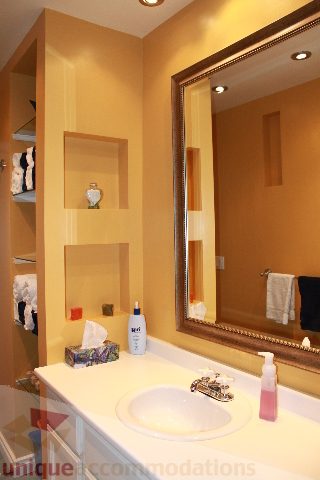 Bathroom with white sink, gold mirror, and neatly arranged toiletries. - 2730 Ailsa Crescent, North Vancouver