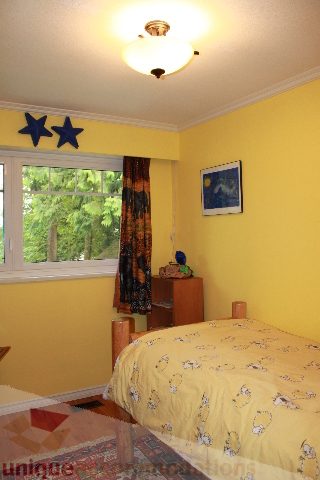 Bright bedroom with yellow walls, star decorations, and a window with a city view. - 2730 Ailsa Crescent, North Vancouver
