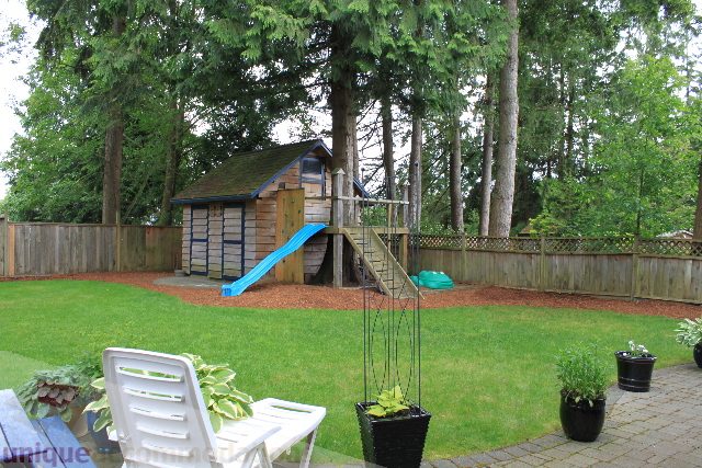 Furnished backyard with wooden playhouse and potted plants. - 2730 Ailsa Crescent, North Vancouver
