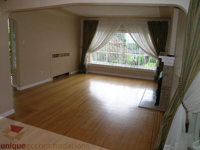 Spacious living room with hardwood floors and large bay window. - 1561 Jefferson Ave, West Vancouver