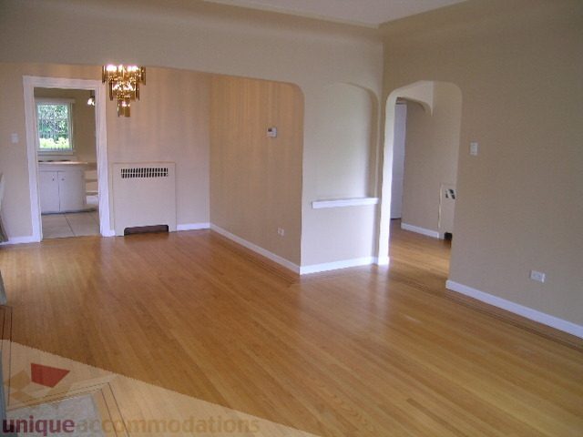 Bright living room with hardwood floors and arched doorways. - 1561 Jefferson Ave, West Vancouver