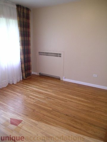 Bright living room with hardwood floors and plaid curtains. - 1561 Jefferson Ave, West Vancouver