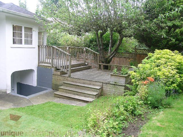 Furnished patio with wooden deck and lush greenery. - 1561 Jefferson Ave, West Vancouver