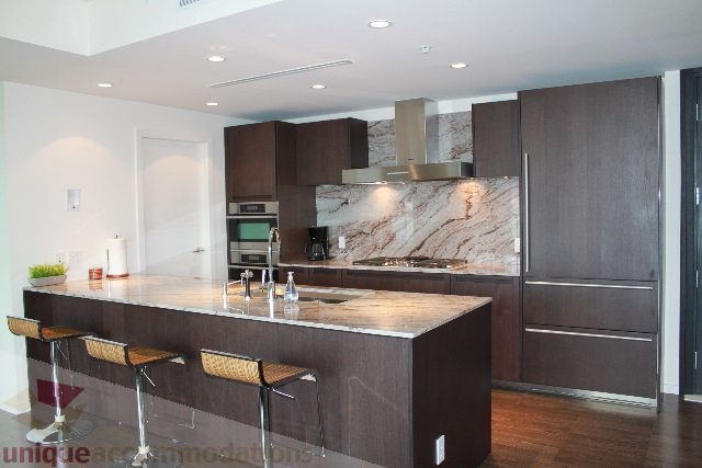 Furnished kitchen with dark wood cabinets and granite countertops. - 3304 - 1011 West Cordova, Vancouver Downtown