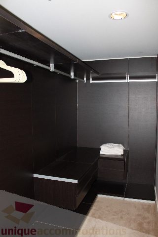 Furnished bedroom with dark wood closet and built-in bench. - 3304 - 1011 West Cordova, Vancouver Downtown