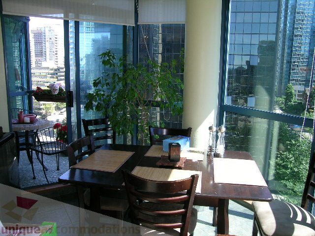 Spacious dining area with large windows offering a stunning city view, modern furnishings, and natural light.