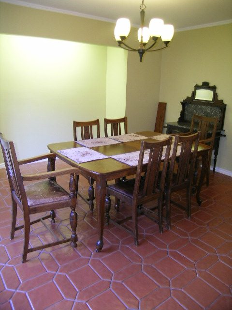 Formal dining room with hexagonal terracotta floor tiles and wooden furniture. - 5753 Westport Road, West Vancouver