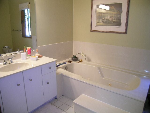 Bright bathroom with white countertops and a bathtub, clean and well-maintained. - 5753 Westport Road, West Vancouver