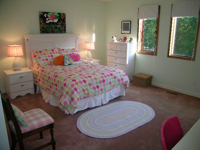 Bright bedroom with polka dot bedding, wooden furniture, and a window view. - 5753 Westport Road, West Vancouver