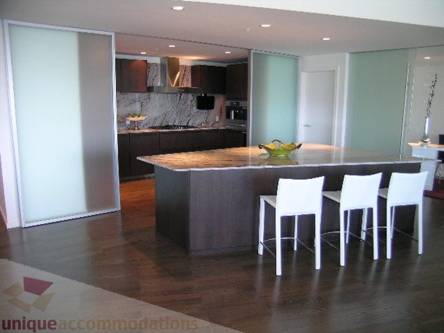 Furnished dining area with modern chairs and dark countertop, hardwood floors. - 3306 - 1011 West Cordova Street, Vancouver Downtown