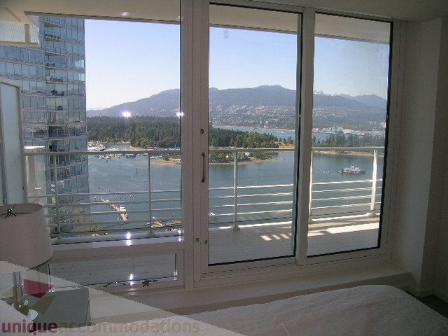 Furnished bedroom with a stunning city view and balcony access. - 3306 - 1011 West Cordova Street, Vancouver Downtown