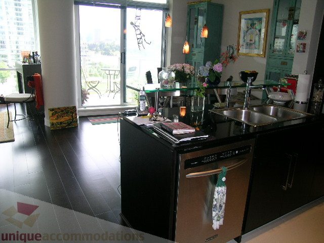 Bright kitchen with black countertops, hardwood floors, and a city view. - 707 - 638 Beach Crescent, Vancouver Downtown