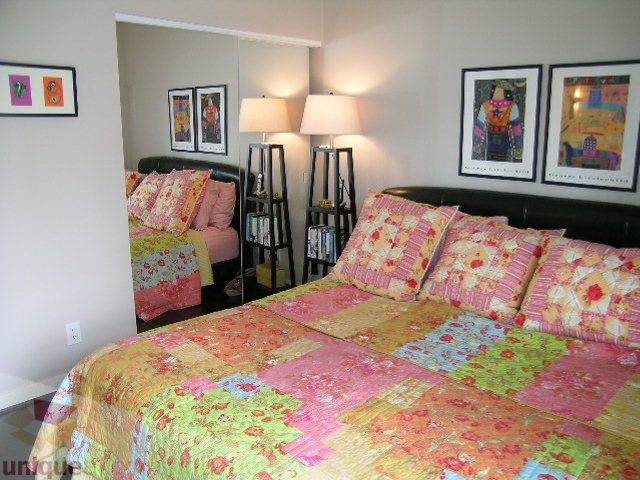 Bright bedroom with colorful patchwork quilt and matching pillows, modern furnishings, and wall art. - 707 - 638 Beach Crescent, Vancouver Downtown