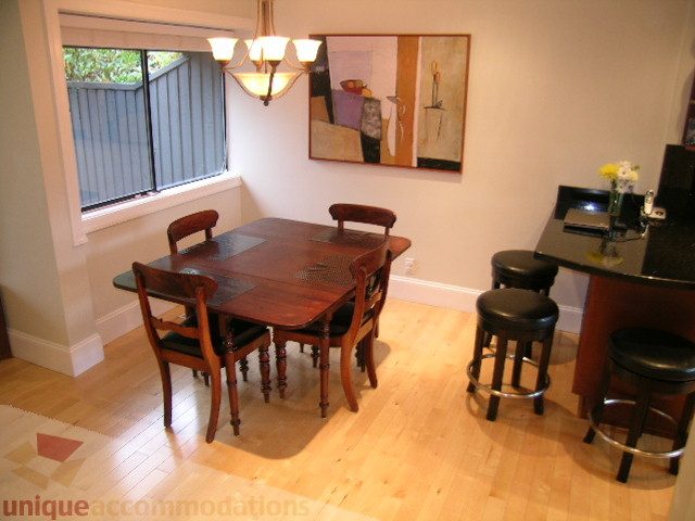 Furnished dining area with wooden table, chairs, and hardwood floors. - 405 - 4001 Mount Seymour Pkwy, North Vancouver