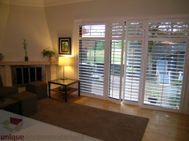 Bright living room with hardwood floors and large windows showing a city view. - 405 - 4001 Mount Seymour Pkwy, North Vancouver