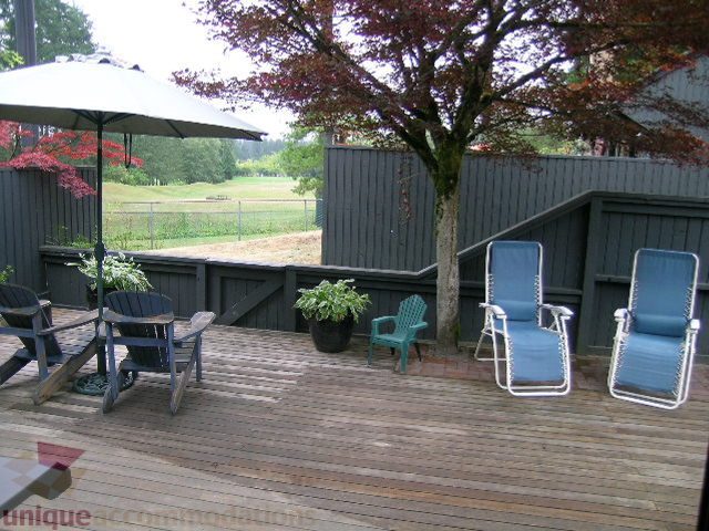 Furnished patio with wooden deck, lounge chairs, and umbrella. - 405 - 4001 Mount Seymour Pkwy, North Vancouver
